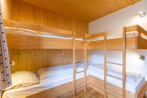 Gemütliches Schlafzimmer mit vier Holz-Etagenbetten in Kreischberg Chalets 21 in Österreich.