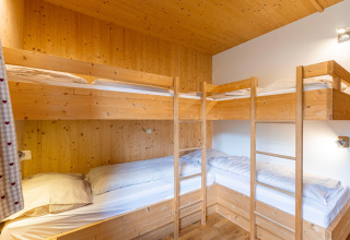 Gemütliches Schlafzimmer mit vier Holz-Etagenbetten in Kreischberg Chalets 21 in Österreich.