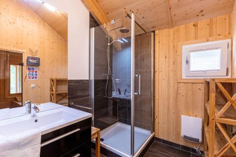 Modernes Badezimmer mit Holzverkleidung, Dusche und Waschbecken im Kreischberg Chalets 21 in Österreich.