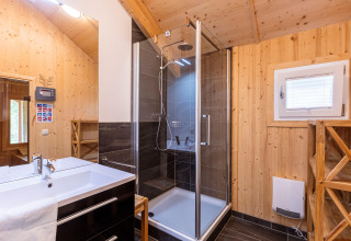 Modernes Badezimmer mit Holzverkleidung, Dusche und Waschbecken im Kreischberg Chalets 21 in Österreich.