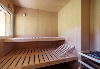 Houten sauna met twee banken, verwarming en raam in Kreischberg Chalets 27 in Oostenrijk.