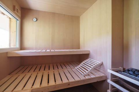 Houten sauna met twee banken, verwarming en raam in Kreischberg Chalets 27 in Oostenrijk.