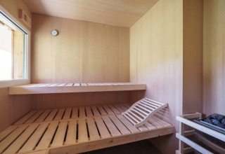 Houten sauna met twee banken, verwarming en raam in Kreischberg Chalets 27 in Oostenrijk.