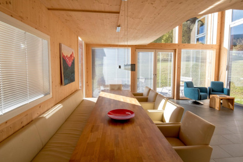 Moderne eethoek bij Kreischberg Chalets 27 in Oostenrijk met grote ramen, houten muren en comfortabele zitplaatsen