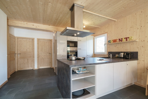 Moderne houten keuken met grijs werkblad en witte kasten in Kreischberg Chalets 27, Oostenrijk.