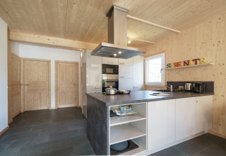 Moderne houten keuken met grijs werkblad en witte kasten in Kreischberg Chalets 27, Oostenrijk.