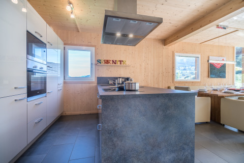 Moderne keuken en eetruimte bij Kreischberg Chalets 27 in Oostenrijk, met houten muren en uitzicht.