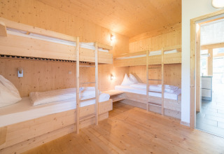 Lichte kamer met vier houten stapelbedden bij Kreischberg Chalets 27, Oostenrijk, houten interieur.