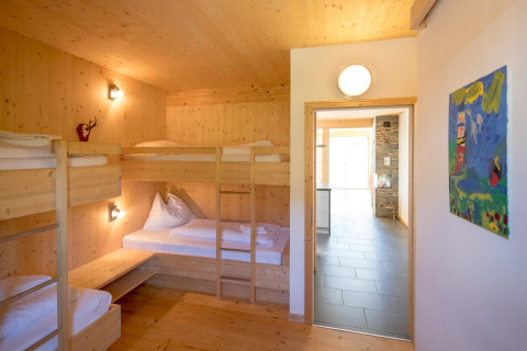 Slaapkamer in Kreischberg Chalets 27, Oostenrijk, met stapelbedden en lichte houten wanden.