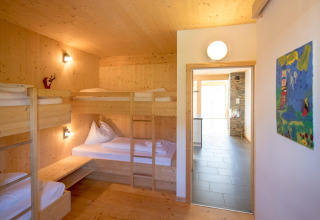 Slaapkamer in Kreischberg Chalets 27, Oostenrijk, met stapelbedden en lichte houten wanden.