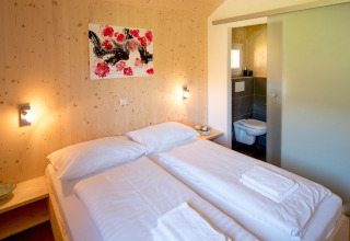 Knusse slaapkamer in Kreischberg Chalets 27 in Oostenrijk met tweepersoonsbed en eigen badkamer.