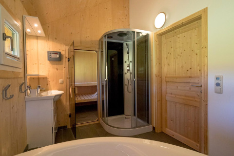 Moderne badkamer met houten panelen bij Kreischberg Chalets 27 in Oostenrijk, met douche en sauna.