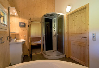 Moderne badkamer met houten panelen bij Kreischberg Chalets 27 in Oostenrijk, met douche en sauna.