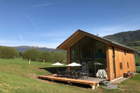 Modern houten lodge met ruim terras en bergzicht bij Kreischberg Chalets 27 in Oostenrijk, op een zonnige dag.