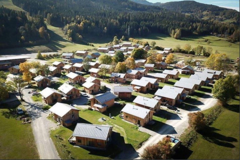 Luchtfoto van Kreischberg Chalets 27 lodge in Oostenrijk, omgeven door groene velden en beboste heuvels.