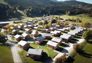 Luchtfoto van Kreischberg Chalets 27 lodge in Oostenrijk, omgeven door groene velden en beboste heuvels.
