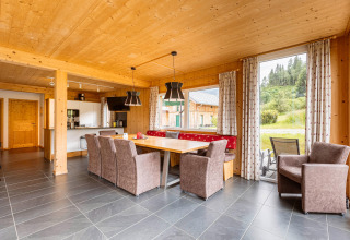 Helles Esszimmer aus Holz im Kreischberg Chalets 26, mit großem Fenster und Blick auf grüne Natur.