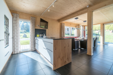 Modernes Küchen- und Esszimmer mit großen Fenstern und Naturblick in den Kreischberg Chalets 26, Österreich.