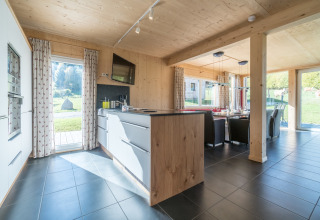 Modernes Küchen- und Esszimmer mit großen Fenstern und Naturblick in den Kreischberg Chalets 26, Österreich.