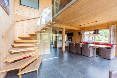 Innenaufnahme von Kreischberg Chalets 26 in Österreich, modernes Holzdesign, offene Treppe und Essbereich.