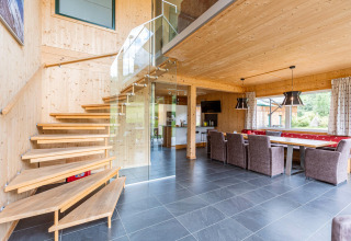 Innenaufnahme von Kreischberg Chalets 26 in Österreich, modernes Holzdesign, offene Treppe und Essbereich.
