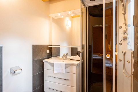 Modernes Badezimmer im Kreischberg Chalets 26 in Österreich mit Duschkabine, Waschtisch und Spiegel.
