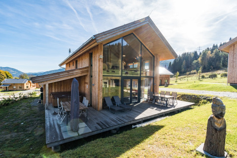 Kreischberg Chalets 26 in Österreich, moderne Holzlodge mit großen Glasfenstern und Terrasse in grüner Umgebung.