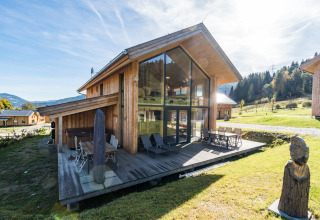 Kreischberg Chalets 26 in Österreich, moderne Holzlodge mit großen Glasfenstern und Terrasse in grüner Umgebung.