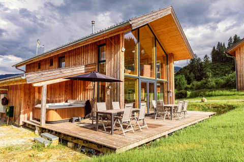 Modernes Holzchalet Kreischberg Chalets 26 in Österreich mit Terrasse, Glasfront und Whirlpool im Freien.