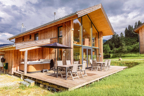 Modernes Holzchalet Kreischberg Chalets 26 in Österreich mit Terrasse, Glasfront und Whirlpool im Freien.