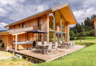 Modernes Holzchalet Kreischberg Chalets 26 in Österreich mit Terrasse, Glasfront und Whirlpool im Freien.