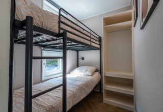 Kamer met stapelbedden en open kast in Groeneborg Lodge, Holiday park De Wiltzangh, Nederland.
