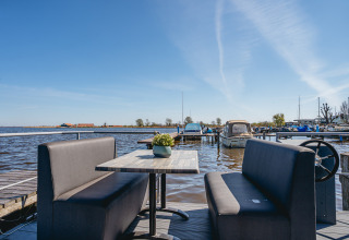 Udsigt fra Houseboat «Havenlodge Plus» i Marina Uitgeest, Holland, med sofaer og både i havnen.