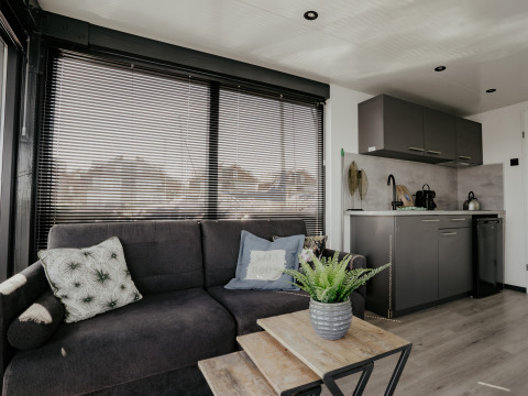 Moderne stue og køkkenområde i husbåd Havenlodge Plus ved Marina Uitgeest, Nederlandene.