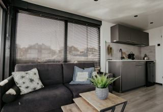 Moderne stue og køkkenområde i husbåd Havenlodge Plus ved Marina Uitgeest, Nederlandene.