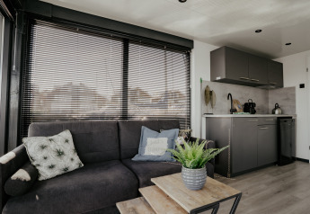 Wohnbereich und moderne Küchenzeile auf Hausboot Havenlodge Plus in der Marina Uitgeest, Niederlande.