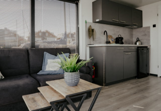 Modern living area and kitchenette on Houseboat Havenlodge Plus at Marina Uitgeest, Netherlands.