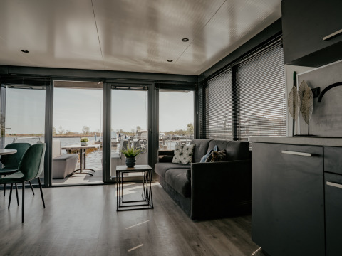 Stilfuld stue ombord på Houseboat «Havenlodge Plus» med udsigt til marinaen i Uitgeest, Holland.