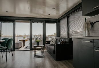 Moderne leefruimte op Houseboat «Havenlodge Plus» met zicht op de haven van Uitgeest, Nederland.