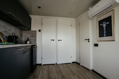 Cucina moderna e ingresso di Houseboat Havenlodge Plus a Marina Uitgeest, Paesi Bassi, con arredo elegante.