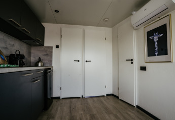 Moderne keuken en inkom van Houseboat Havenlodge Plus aan Marina Uitgeest, Nederland, met stijlvol decor.
