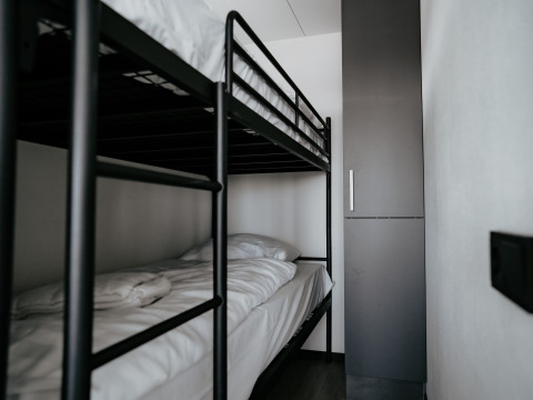 Modern bunk bed and closet in a minimalist room on Houseboat Havenlodge Plus at Marina Uitgeest, Netherlands.