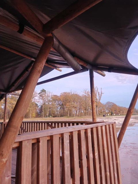 Vista dalla tenda safari con terrazza in legno sul lago presso il Camping De Rammelbeek nei Paesi Bassi.