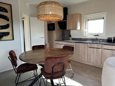 Moderne eethoek en keuken in Zonneweelde Lodge Deluxe op Camping Zonneweelde, Nederland.