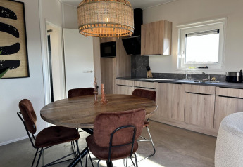 Zona pranzo moderna e cucina nella Zonneweelde Lodge Deluxe al Camping Zonneweelde, Paesi Bassi.