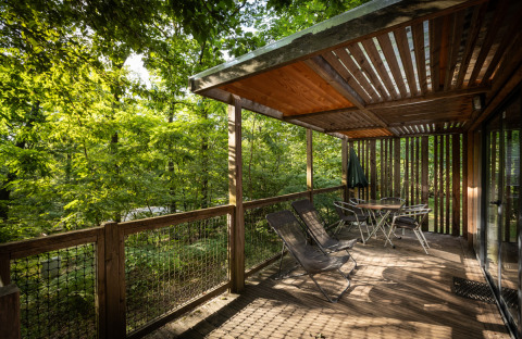 Holzveranda des Mobile home Vancouver bei Huttopia Wattwiller, Frankreich, im grünen Wald gelegen.