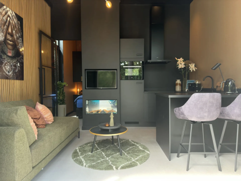Moderne lodge woonkamer en keuken in Veluwe Suite met sauna bij Camping Samoza in Nederland.