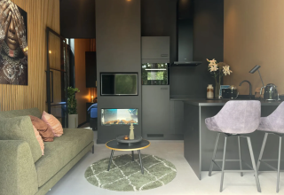 Moderne lodge woonkamer en keuken in Veluwe Suite met sauna bij Camping Samoza in Nederland.