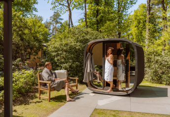 Outdoor relaxation at Veluwe Suite met sauna at Camping Samoza in the Netherlands with two people in robes.