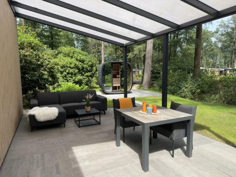Überdachte Terrasse mit modernen Gartenmöbeln an der Veluwe Suite met sauna auf Camping Samoza, Niederlande.
